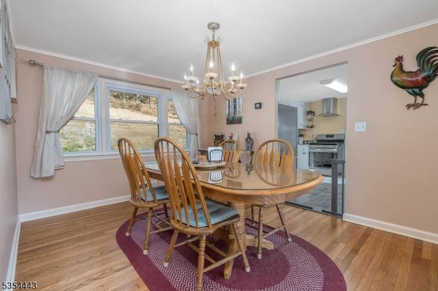 dining area with a chandelier, crown molding, light wood finished floors, and baseboards