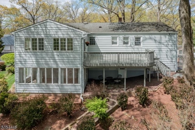 back of house featuring a patio, a shingled roof, a deck, and stairway