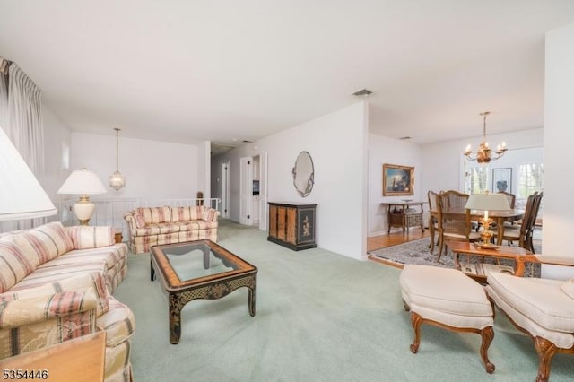 living area with visible vents, a notable chandelier, and light carpet