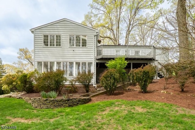 rear view of house featuring a yard and a deck