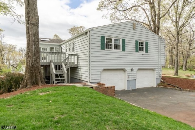 exterior space featuring a lawn, a deck, an attached garage, driveway, and stairway