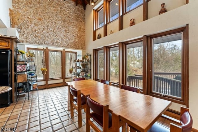 dining space with light tile patterned floors and a high ceiling