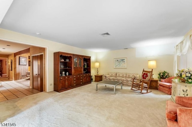 living room featuring light colored carpet, light tile patterned flooring, and visible vents