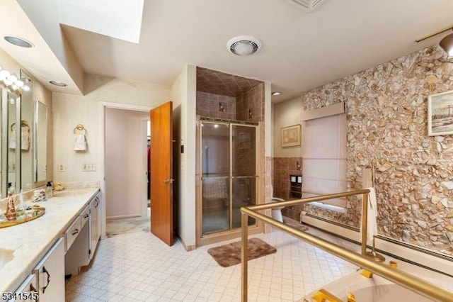 bathroom featuring baseboard heating, a sink, double vanity, visible vents, and a stall shower