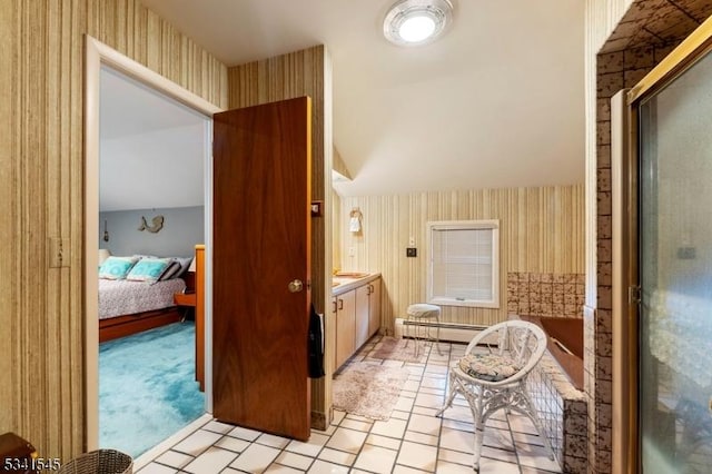 ensuite bathroom featuring vanity, baseboard heating, wallpapered walls, and lofted ceiling