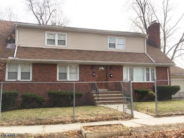 view of front facade with a chimney and brick siding