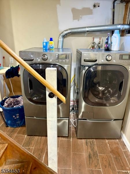 washroom with washer and dryer and wood finish floors