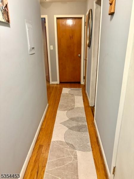 hallway featuring wood finished floors and baseboards