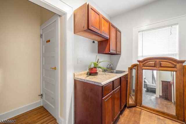 104 Riggs Pl, West Orange Twp, NJ 07052 - kitchen with brown cabinets, light wood-type flooring, a sink, light countertops, and baseboards