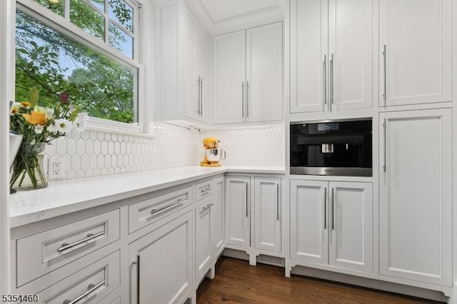 bar area featuring decorative backsplash, dark wood finished floors, and oven