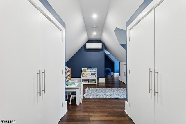 hallway with a wall unit AC, wood finished floors, vaulted ceiling, and recessed lighting