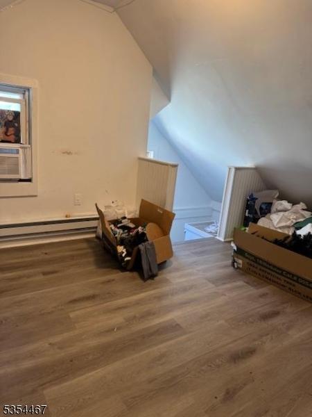 252 Spring St, Newton Town, NJ 07860 - additional living space with lofted ceiling, wood finished floors, baseboard heating, and cooling unit