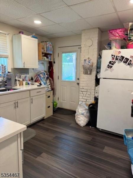 252 Spring St, Newton Town, NJ 07860 - kitchen featuring freestanding refrigerator, light countertops, dark wood-type flooring, white cabinets, and a paneled ceiling