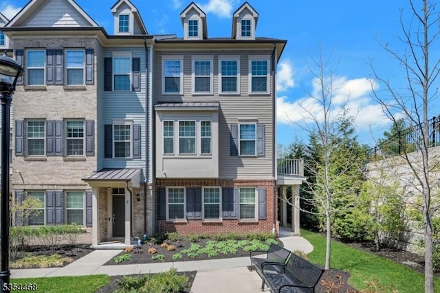 townhome / multi-family property with brick siding and a patio area