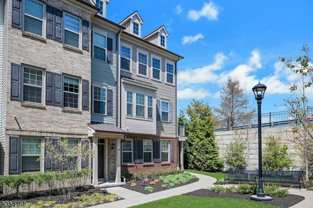 townhome / multi-family property with brick siding and fence