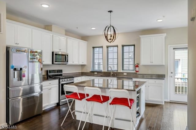 kitchen featuring a sink, appliances with stainless steel finishes, a center island, and white cabinetry