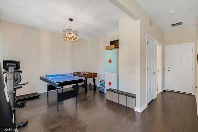 recreation room featuring baseboards, a notable chandelier, wood finished floors, and visible vents