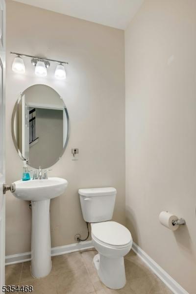 bathroom with tile patterned floors, baseboards, and toilet
