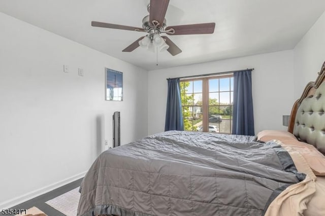 bedroom featuring baseboards, ceiling fan, and wood finished floors