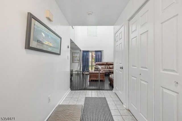 hall featuring baseboards and light tile patterned floors