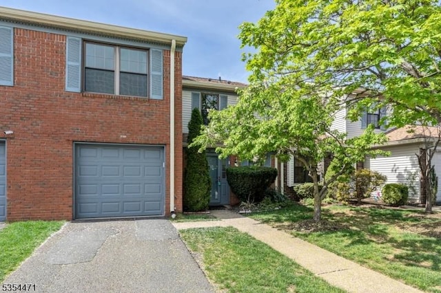 view of front facade featuring brick siding, a garage, and aphalt driveway