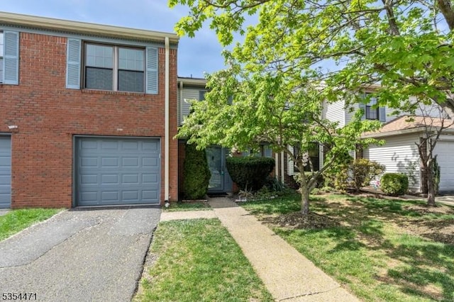 view of property with a garage, driveway, and brick siding