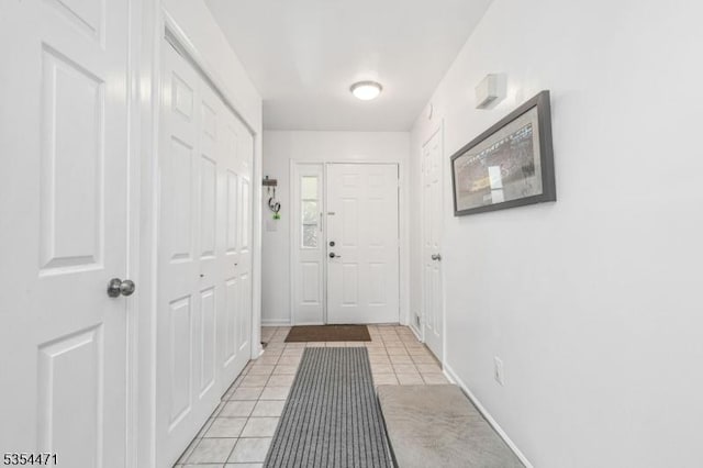 doorway to outside with baseboards and light tile patterned floors