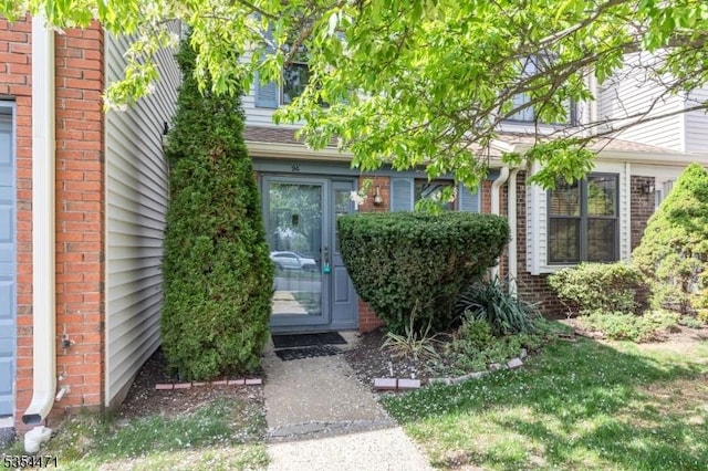 doorway to property featuring brick siding