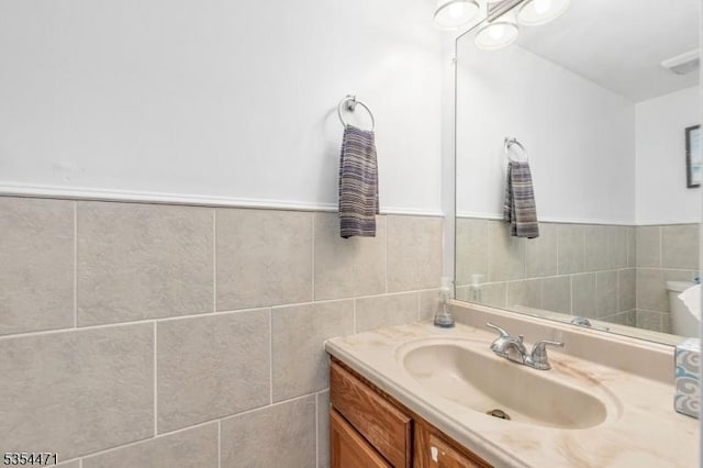 bathroom with vanity and tile walls