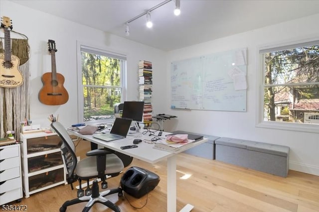 home office featuring rail lighting and wood finished floors