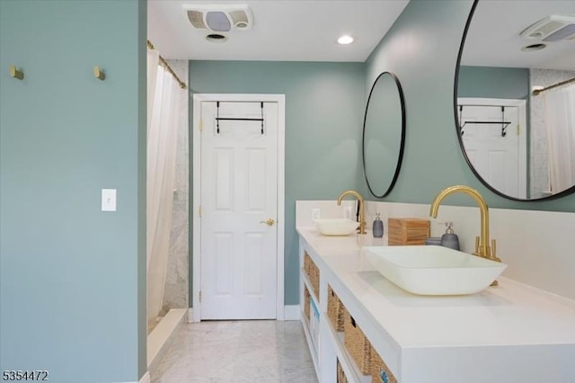 full bath with a sink, a shower with shower curtain, and marble finish floor