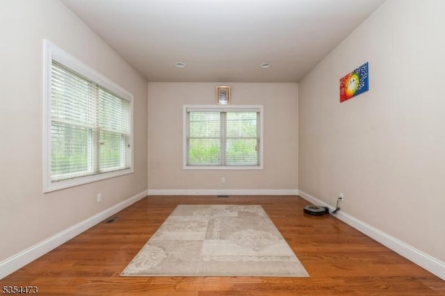 unfurnished room featuring baseboards and wood finished floors