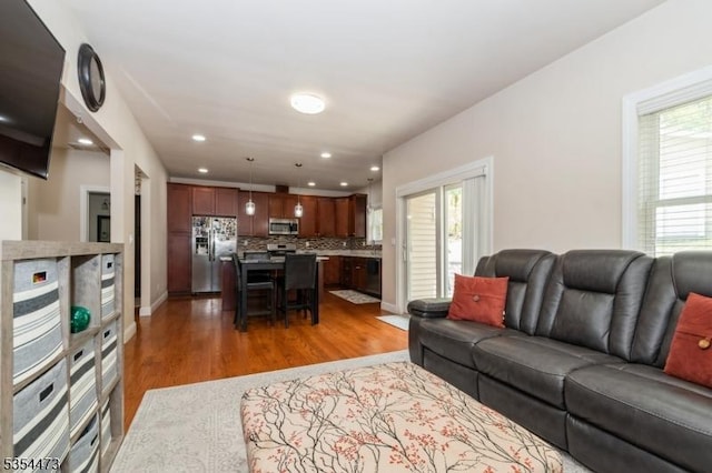 living area featuring recessed lighting, plenty of natural light, and wood finished floors