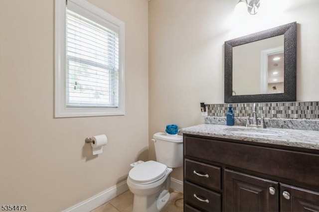 bathroom with plenty of natural light, baseboards, tile patterned flooring, and toilet