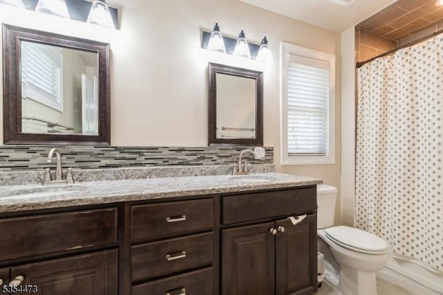 full bath with a sink, decorative backsplash, and toilet