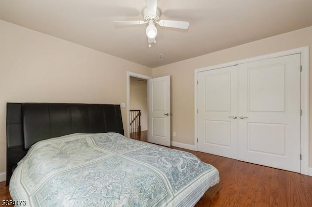 bedroom featuring baseboards, ceiling fan, wood finished floors, and a closet