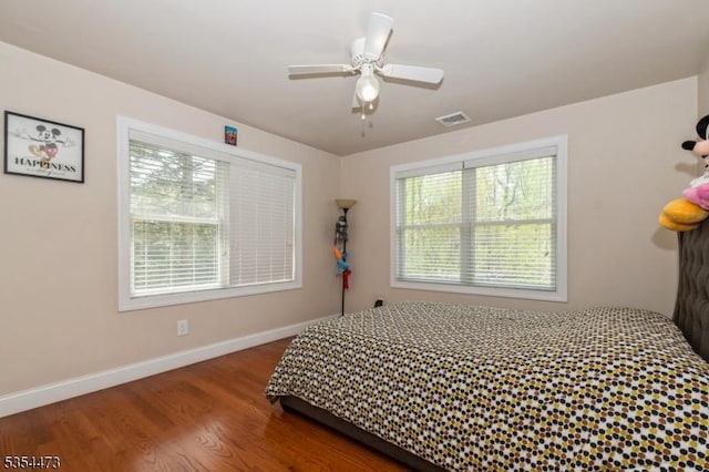 bedroom with ceiling fan, baseboards, visible vents, and wood finished floors