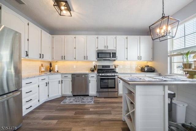 kitchen featuring white cabinetry, appliances with stainless steel finishes, a wealth of natural light, and dark wood finished floors