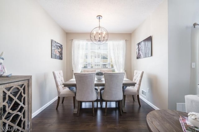 dining room with baseboards, an inviting chandelier, wood finished floors, and visible vents