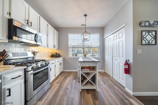 kitchen with white cabinets, stainless steel appliances, and baseboards