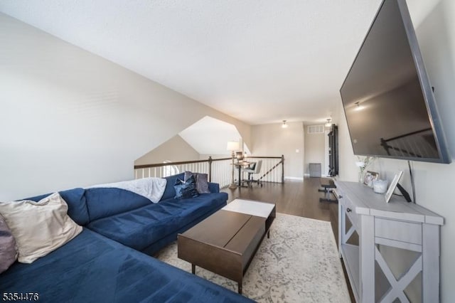 living room featuring visible vents, baseboards, and wood finished floors