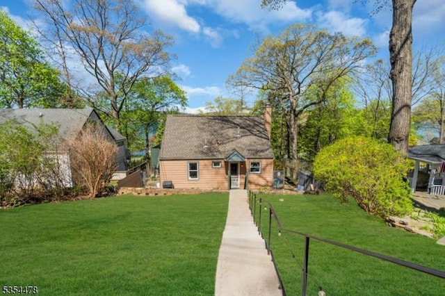 view of front facade with fence, a chimney, and a front yard