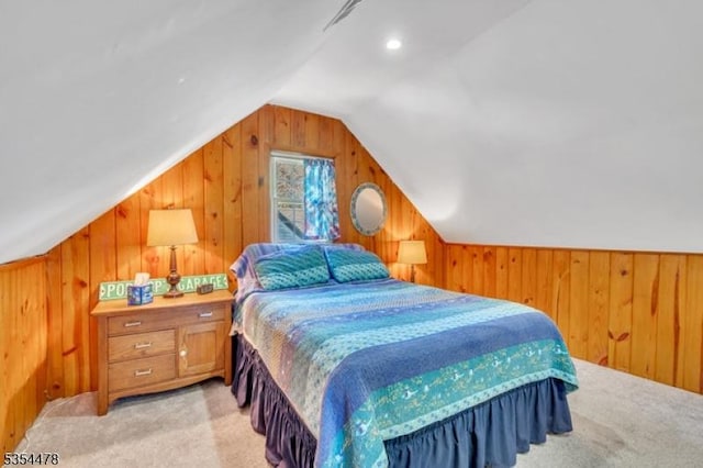 bedroom with light carpet, wood walls, and lofted ceiling