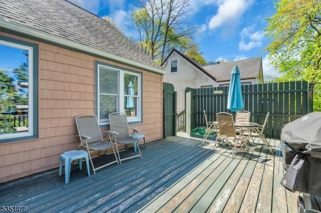 wooden terrace featuring outdoor dining space and area for grilling