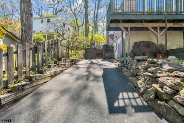 exterior space featuring fence, stucco siding, and driveway