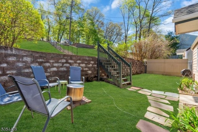 view of yard featuring a fenced backyard and stairway