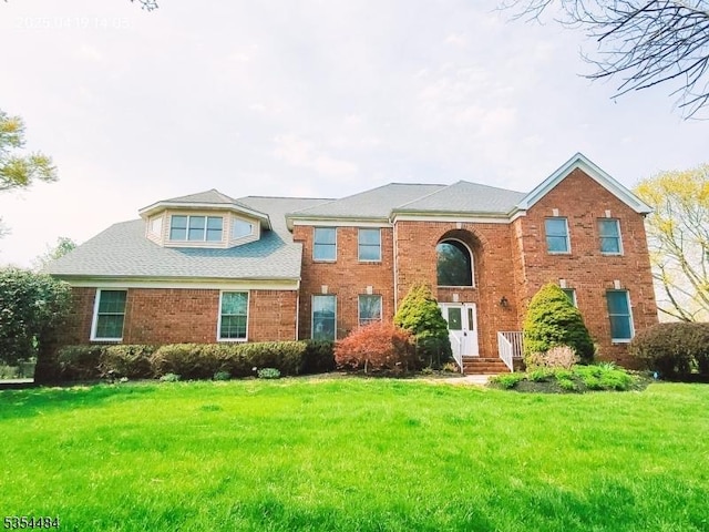 view of front of property featuring brick siding and a front lawn