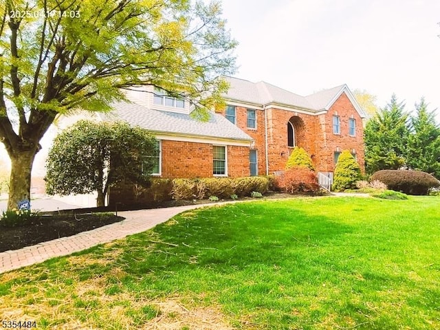 traditional-style house featuring brick siding and a front yard