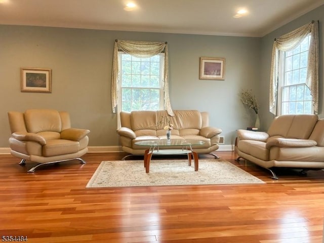 living area with recessed lighting, baseboards, ornamental molding, and wood finished floors