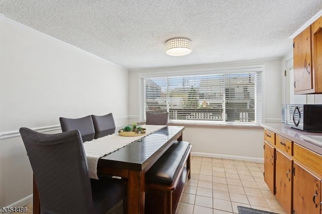 dining area featuring baseboards, a textured ceiling, and light tile patterned floors